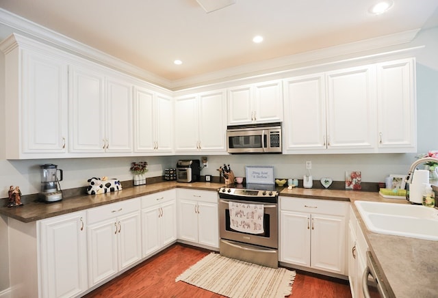 351 Virginia Cir, Cairo, GA 39828 - kitchen with appliances with stainless steel finishes, a sink, wood finished floors, white cabinetry, and recessed lighting