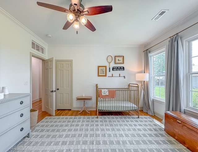 1267 Quincy Hwy, Attapulgus, GA 39815 - bedroom featuring light wood-type flooring, multiple windows, crown molding, baseboards, and a ceiling fan