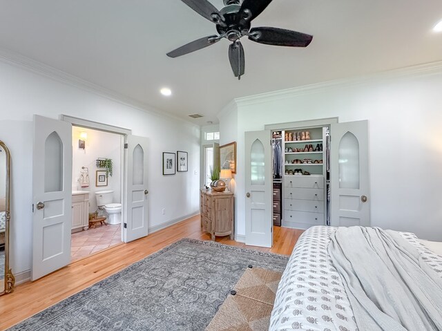 1267 Quincy Hwy, Attapulgus, GA 39815 - bedroom with crown molding, light wood-type flooring, a walk in closet, ensuite bath, and ceiling fan