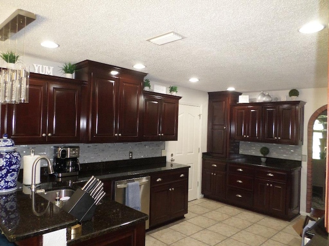 kitchen with decorative backsplash, a textured ceiling, dishwasher, a sink, and light tile patterned flooring