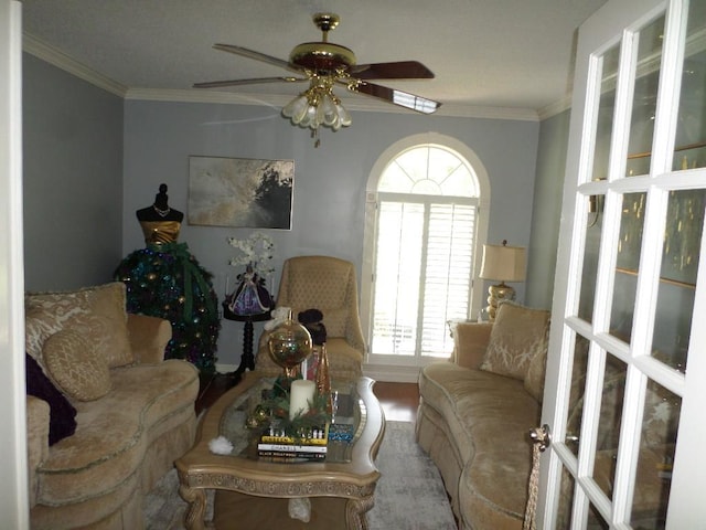 living area featuring a ceiling fan, wood finished floors, and ornamental molding