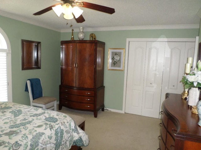 bedroom with crown molding, a closet, light carpet, and ceiling fan