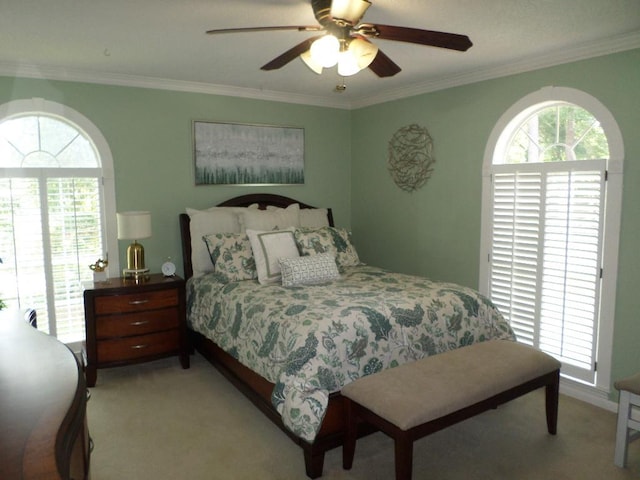 bedroom with crown molding, ceiling fan, and light carpet
