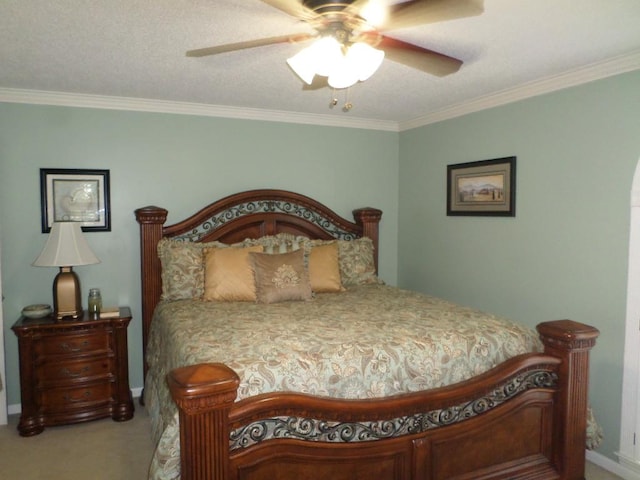 carpeted bedroom with ceiling fan, ornamental molding, and baseboards