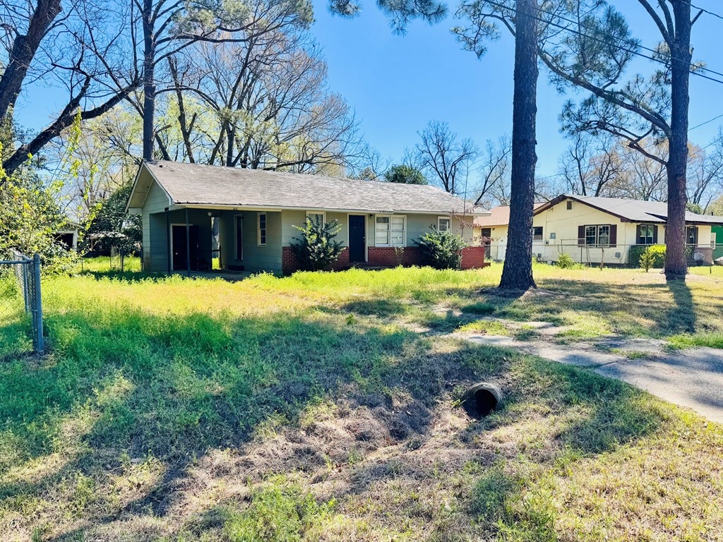 single story home featuring fence