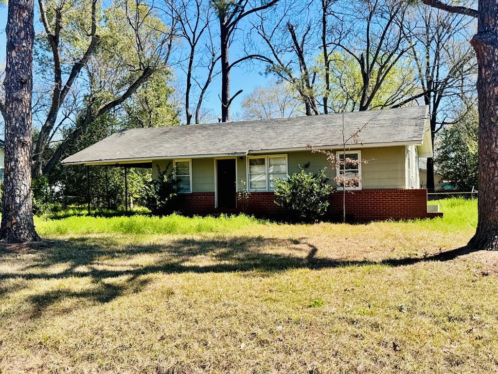 ranch-style house featuring brick siding and a front lawn