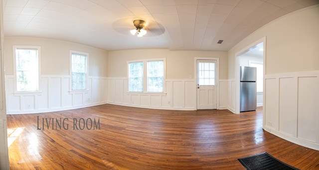 641 Evans, Bainbridge, GA 39819 - unfurnished room featuring ceiling fan, a wainscoted wall, dark wood-style floors, a decorative wall, and lofted ceiling