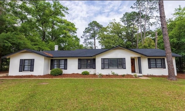 single story home featuring a chimney and a front lawn