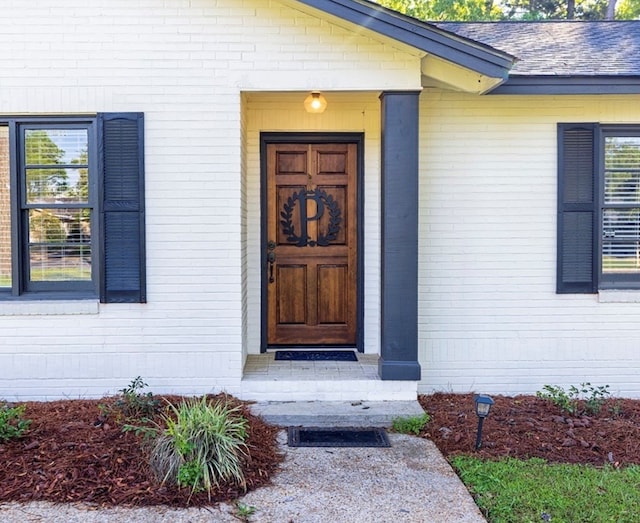 doorway to property featuring brick siding