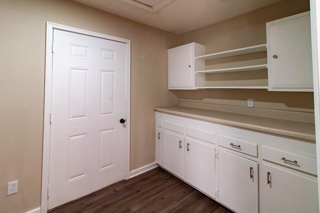 kitchen featuring open shelves, dark wood-style floors, white cabinetry, light countertops, and baseboards