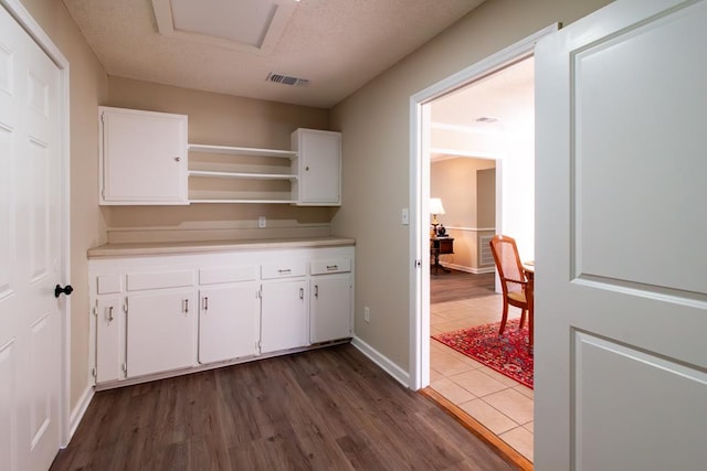 kitchen with visible vents, light countertops, dark wood-style floors, white cabinets, and open shelves