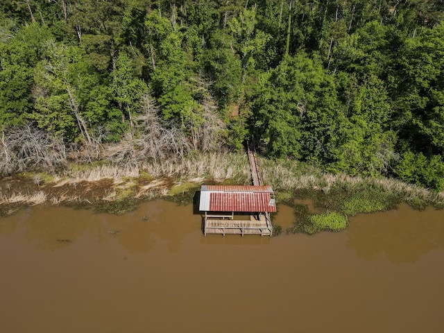 drone / aerial view featuring a wooded view and a water view