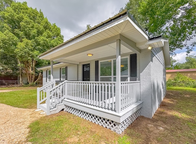 view of front of property with covered porch and a front yard