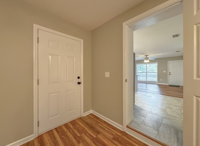 doorway featuring ceiling fan and light hardwood / wood-style flooring