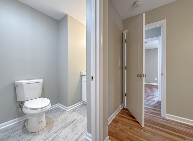 bathroom with vanity, hardwood / wood-style flooring, and toilet