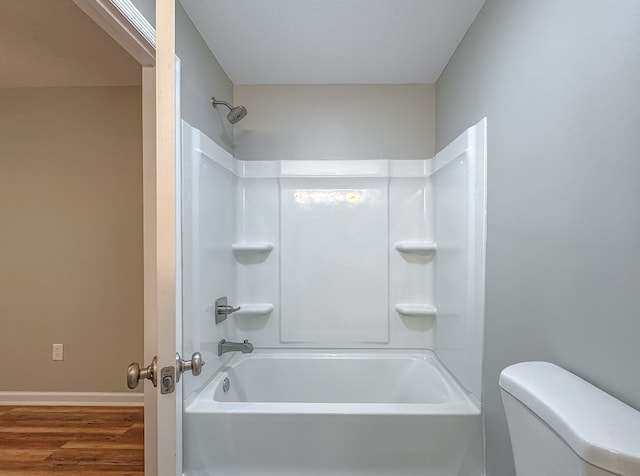 bathroom featuring hardwood / wood-style flooring, toilet, and shower / bath combination