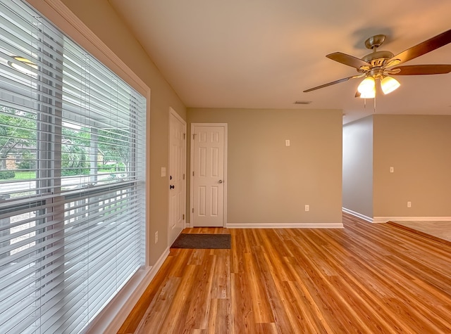 empty room with ceiling fan and light hardwood / wood-style flooring