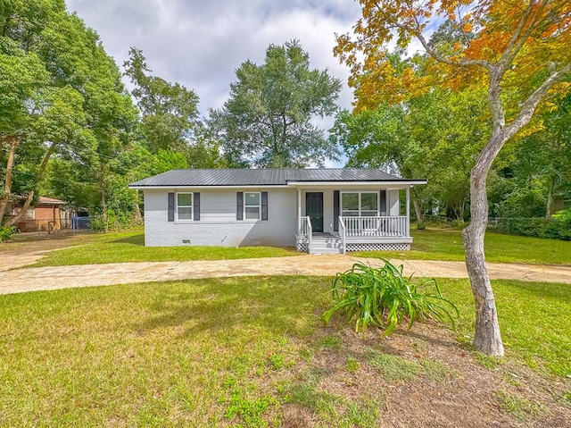 ranch-style house featuring covered porch and a front lawn