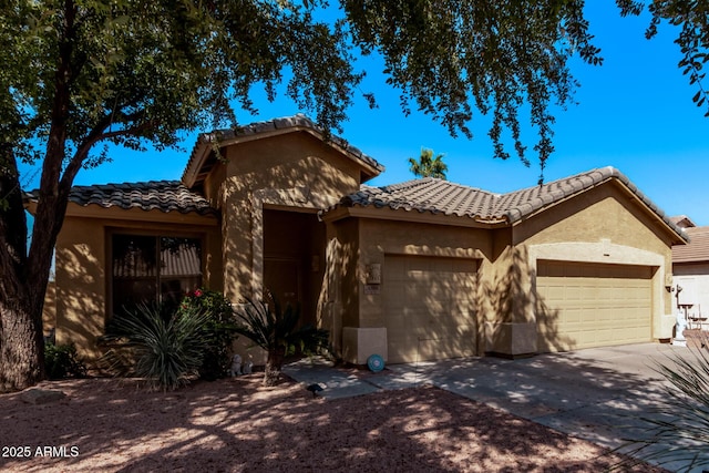 view of front of house featuring a tile roof, stucco siding, an attached garage, and concrete driveway