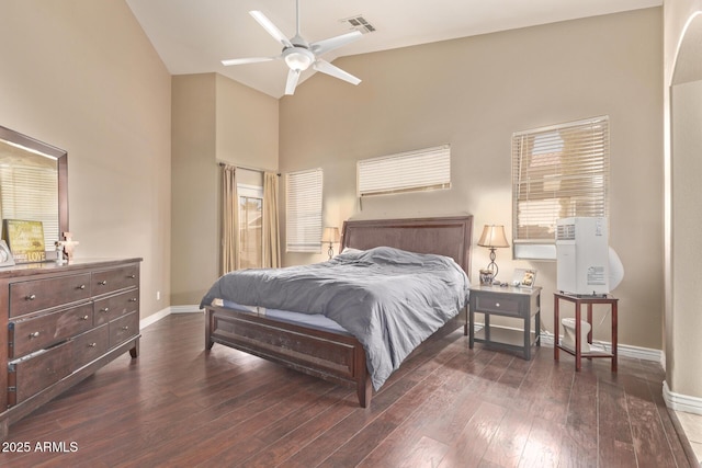 bedroom with baseboards, wood-type flooring, high vaulted ceiling, and visible vents