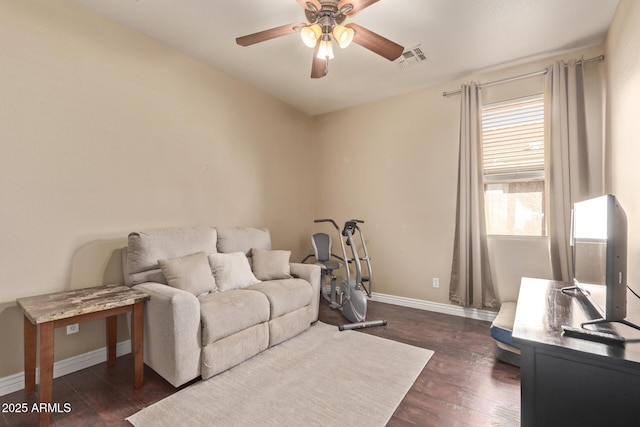 living area featuring ceiling fan, dark wood-style floors, visible vents, and baseboards