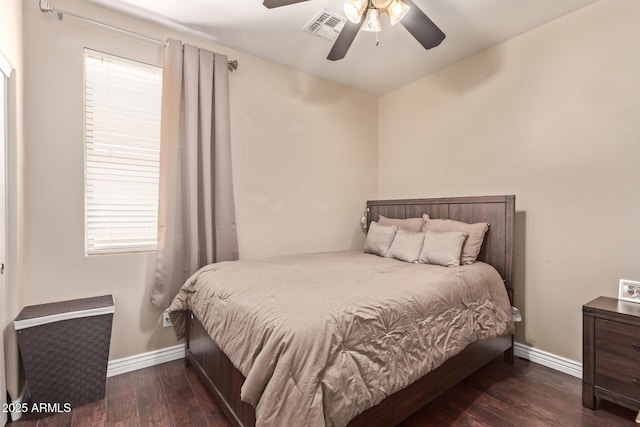 bedroom featuring ceiling fan, visible vents, baseboards, and wood finished floors