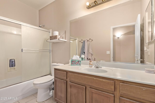 bathroom with combined bath / shower with glass door, toilet, vanity, and tile patterned flooring