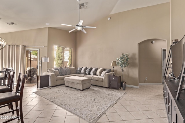 living area with visible vents, arched walkways, light tile patterned flooring, high vaulted ceiling, and a ceiling fan