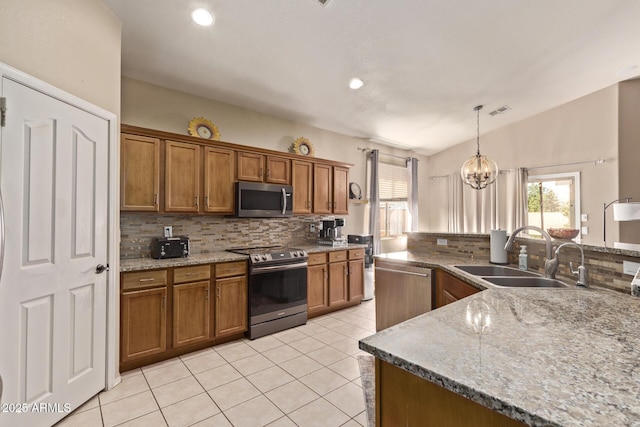 kitchen with tasteful backsplash, brown cabinets, appliances with stainless steel finishes, and a sink