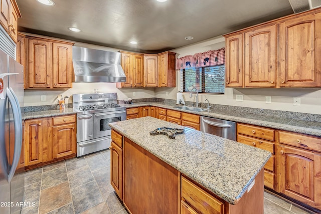 kitchen featuring recessed lighting, stainless steel appliances, a sink, a center island, and wall chimney exhaust hood