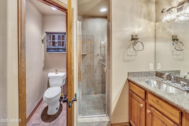 full bathroom featuring baseboards, toilet, tile patterned flooring, vanity, and a shower stall