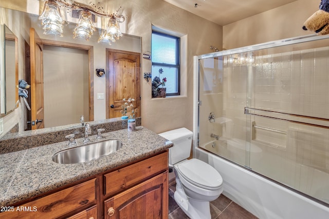 full bathroom with toilet, tile patterned flooring, bath / shower combo with glass door, and vanity