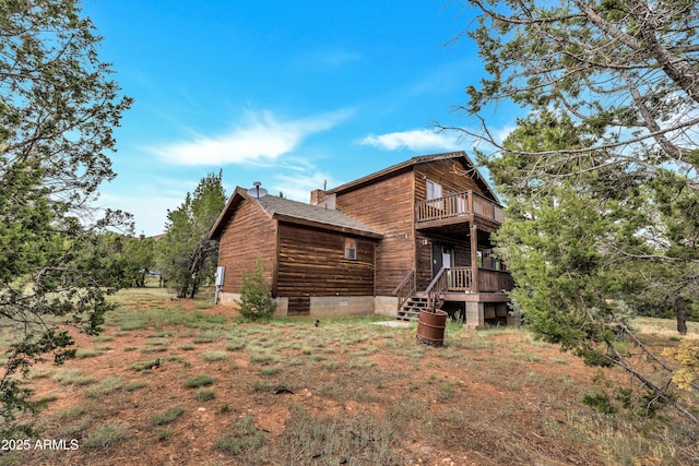 view of property exterior featuring a shingled roof, a chimney, and a balcony