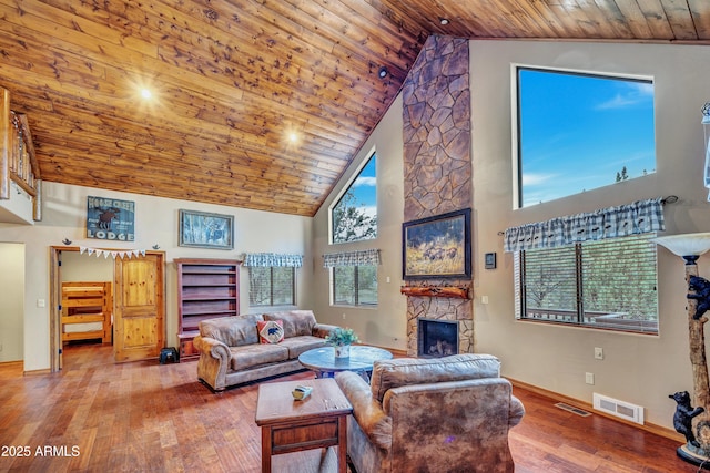 living area with wooden ceiling, visible vents, a fireplace, and hardwood / wood-style floors