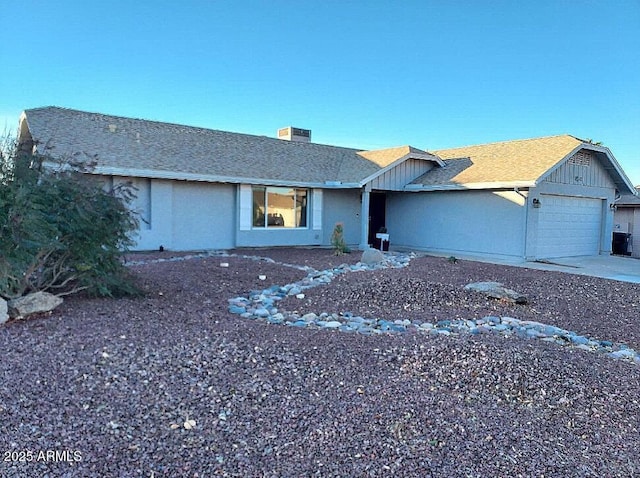 ranch-style house featuring central AC and a garage