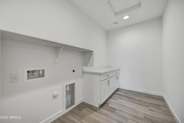 laundry area featuring hookup for a washing machine, light hardwood / wood-style flooring, hookup for a gas dryer, and hookup for an electric dryer