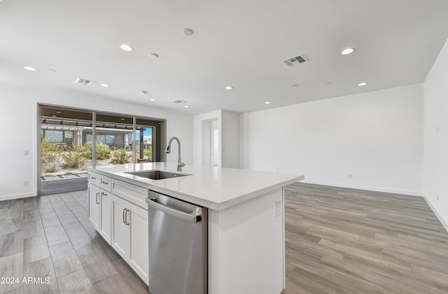 kitchen with dishwasher, light hardwood / wood-style floors, sink, an island with sink, and white cabinetry