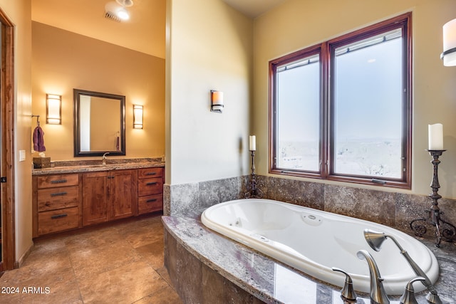 bathroom featuring tiled bath and vanity