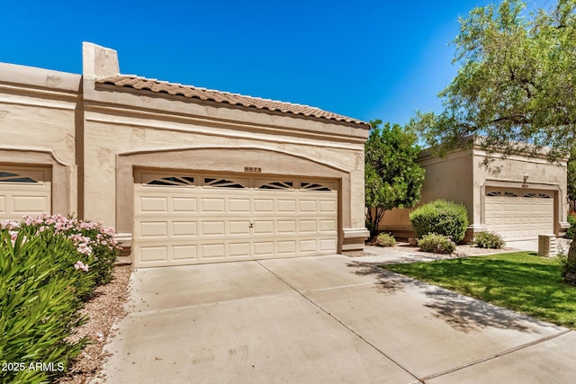 8874 W Piute Ave, Peoria, AZ 85382 - view of front of house with stucco siding, a garage, a tiled roof, and driveway