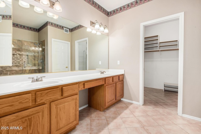 8874 W Piute Ave, Peoria, AZ 85382 - bathroom featuring double vanity, a stall shower, a walk in closet, tile patterned floors, and baseboards
