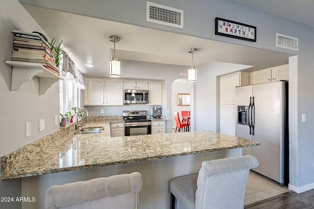 kitchen with kitchen peninsula, white cabinets, stainless steel appliances, and light hardwood / wood-style floors