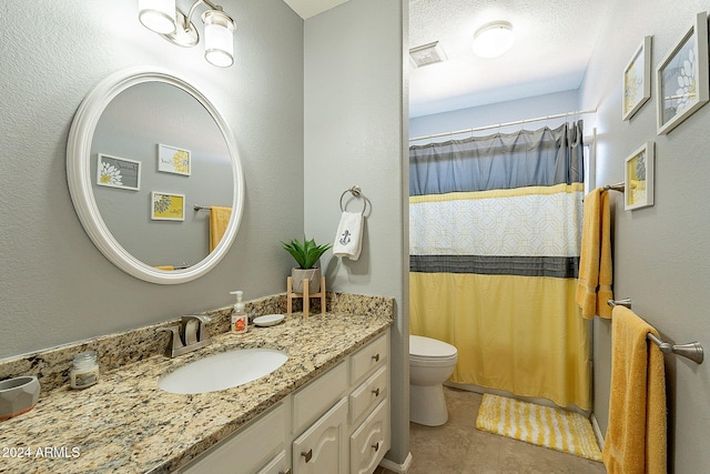 bathroom with a textured ceiling, vanity, tile patterned flooring, toilet, and curtained shower