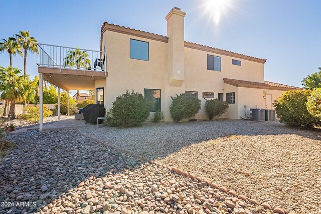 242 E Stonebridge Dr, Gilbert, AZ 85234 - rear view of house featuring stucco siding, a patio, a balcony, central AC unit, and a chimney