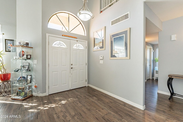 foyer featuring dark hardwood / wood-style floors and a towering ceiling