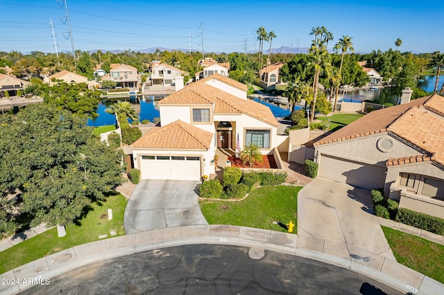 242 E Stonebridge Dr, Gilbert, AZ 85234 - mediterranean / spanish house with a residential view, concrete driveway, stucco siding, a tile roof, and a water view
