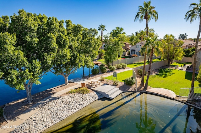 view of home's community with a lawn, a patio area, and a water view