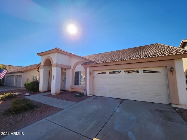 3853 W Calle Lejos, Glendale, AZ 85310 - mediterranean / spanish-style home featuring driveway, a garage, stucco siding, and a tiled roof