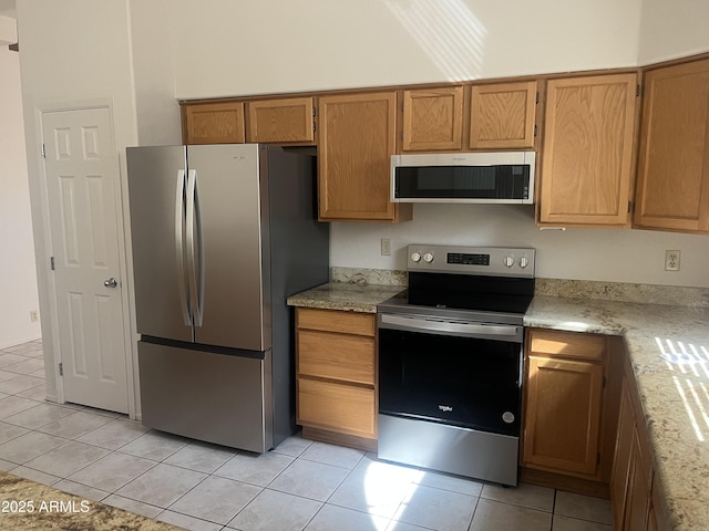 3853 W Calle Lejos, Glendale, AZ 85310 - kitchen with appliances with stainless steel finishes, light tile patterned floors, and brown cabinets