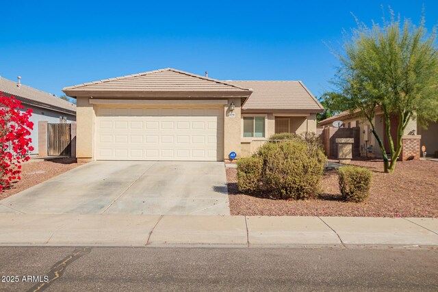 ranch-style house featuring fence, a tile roof, concrete driveway, stucco siding, and an attached garage