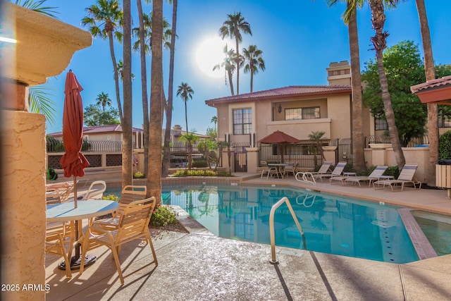 pool featuring fence and a patio area